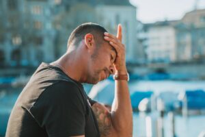手をおでこに当てる男性